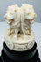 Carved Ashoka lions with dharmachakra motifs on a tiered black base