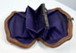 Side view of antique bone coin purse with expandable brown leather construction