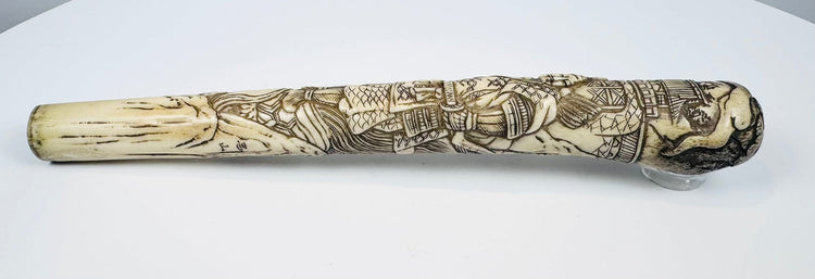 Detailed Meiji-period bone handle with darkened engraved samurai decoration