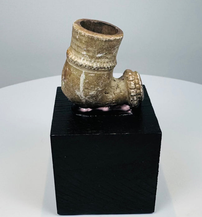 Antique ceramic pipe bowl with brown patina and pale mineral-like deposits