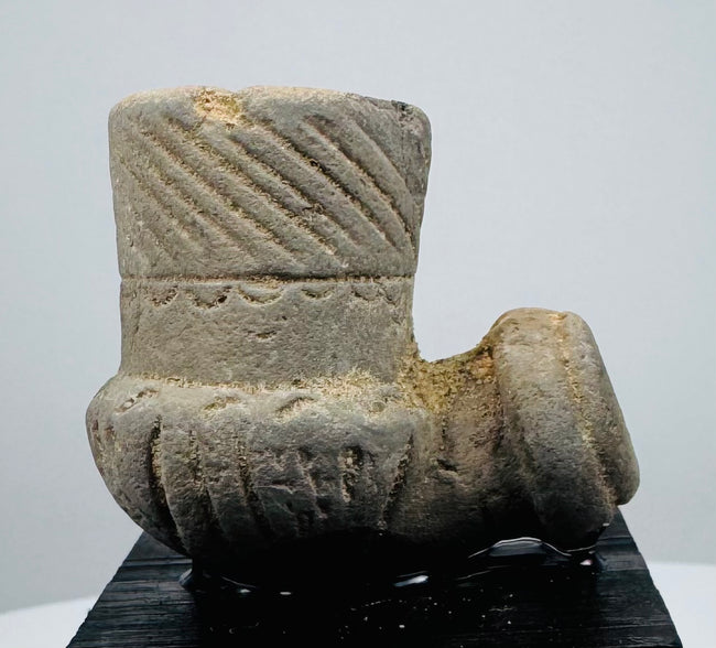 Archaeological North American smoking pipe with mineral deposits and worn carved details