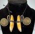 Close-up of aged animal teeth secured with black woven cord and brass ornamentation