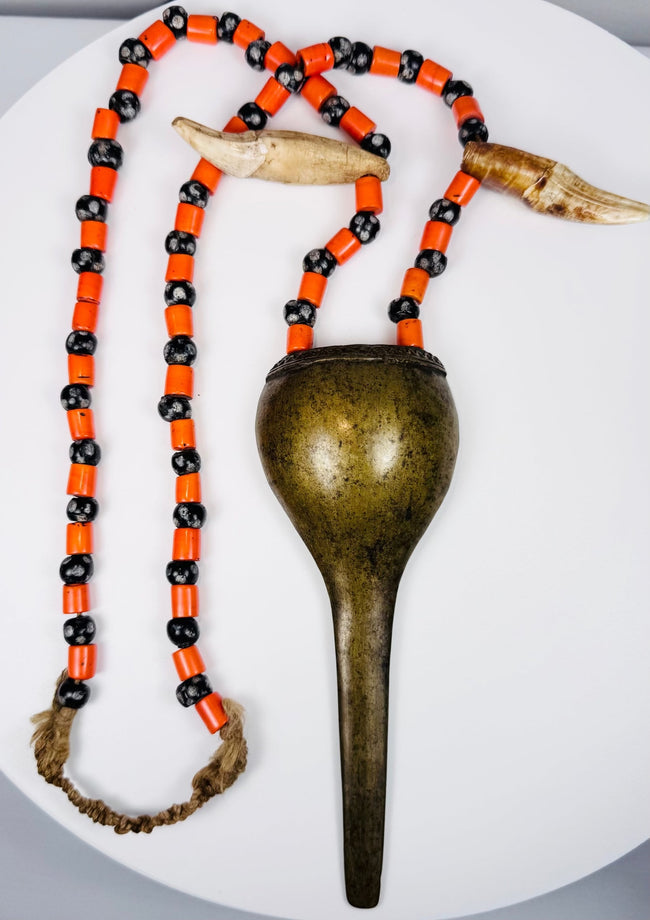 Antique Konyak prestige jewellery with stylized shell-form brass pendant and trade beads