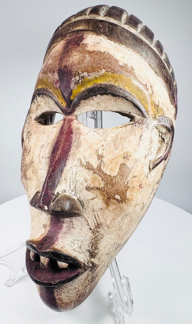 Profile view of a hand-carved Yombe mask showing its projecting facial features