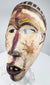 Profile view of a hand-carved Yombe mask showing its projecting facial features
