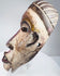 Antique African tribal mask featuring carved teeth and a deeply ridged coiffure