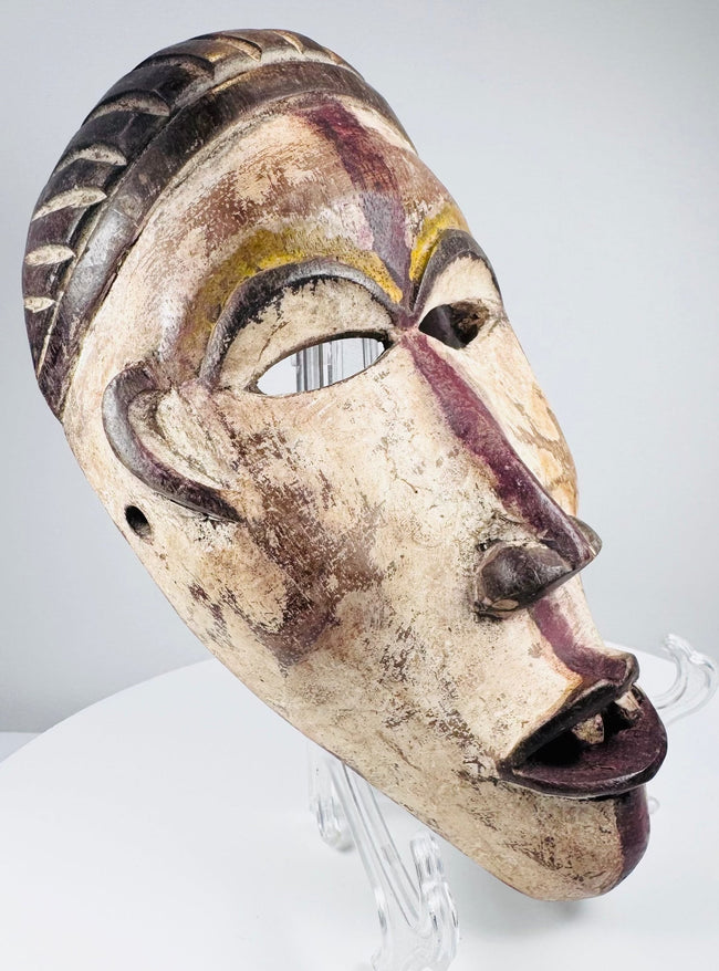 Hand-carved Lower Congo mask displaying aged pigment, abrasions and surface patina