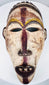 Front view of a carved Yombe mask with narrow eyes, prominent nose and open mouth