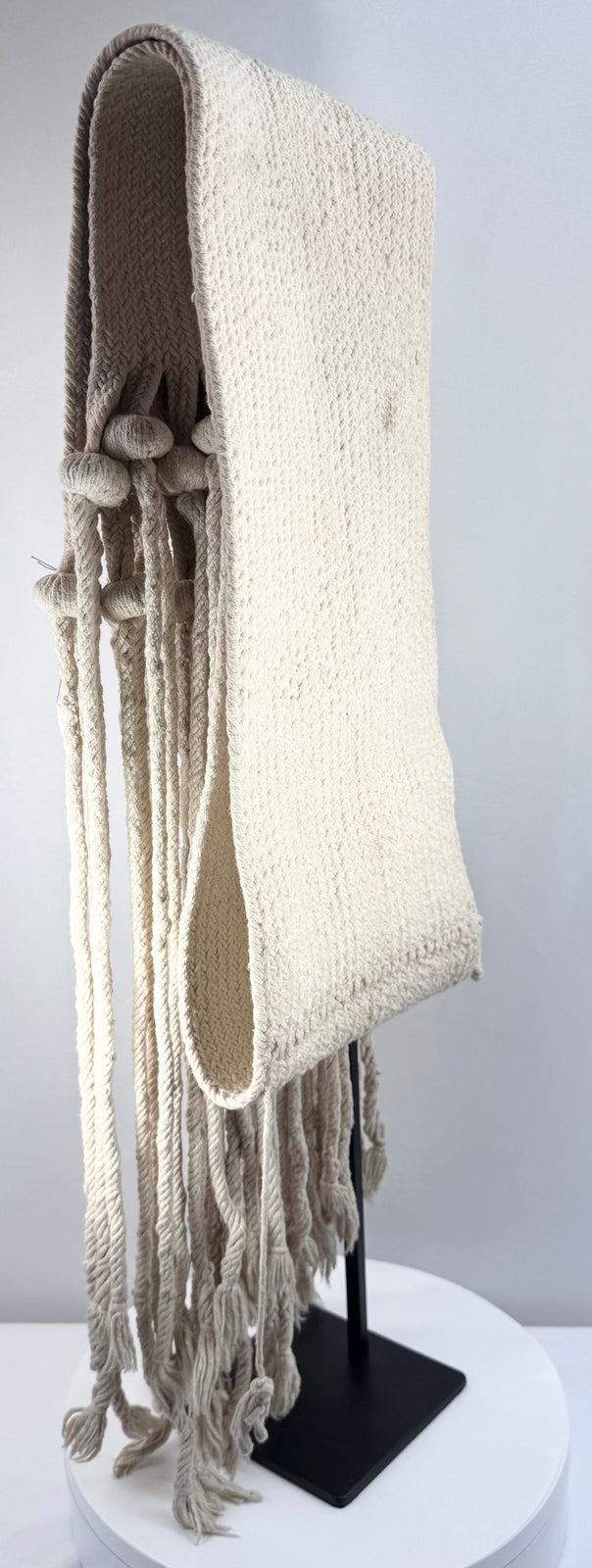 Side view of a long Hopi-style cotton sash showing its sculptural tassel arrangement