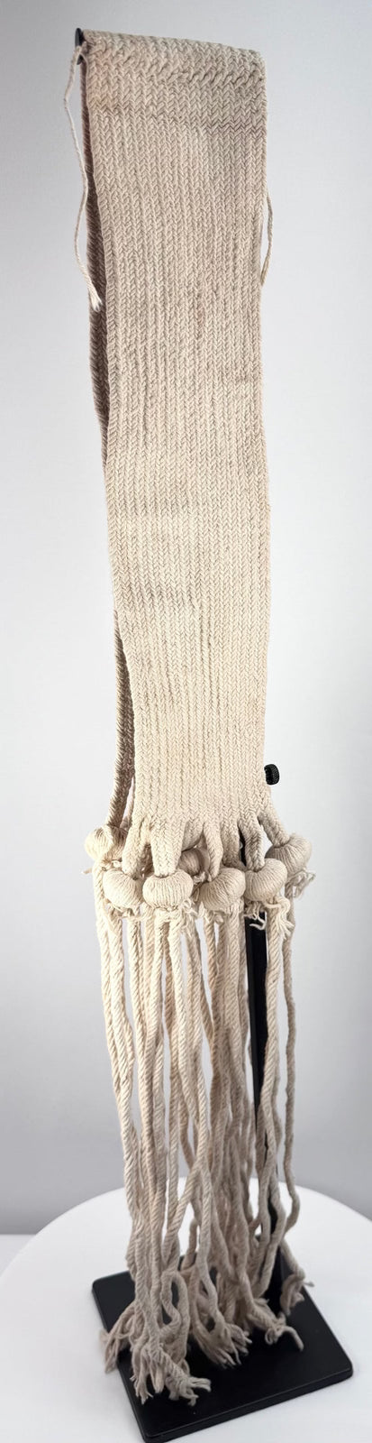 Close view of suspended cotton cords and wrapped ceremonial knots on a Pueblo sash