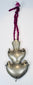 Antique Chinese double crescent amulet pendant suspended from an aged magenta textile cord