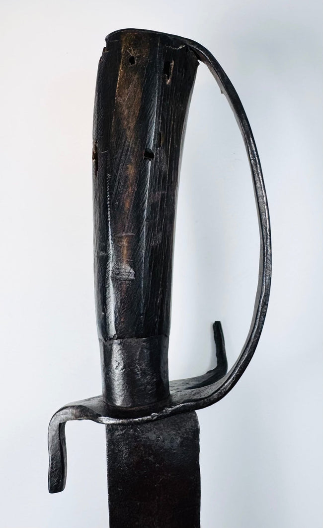 Detail of the iron ferrule and plain pommel cap on a blacksmith-made hanger sword