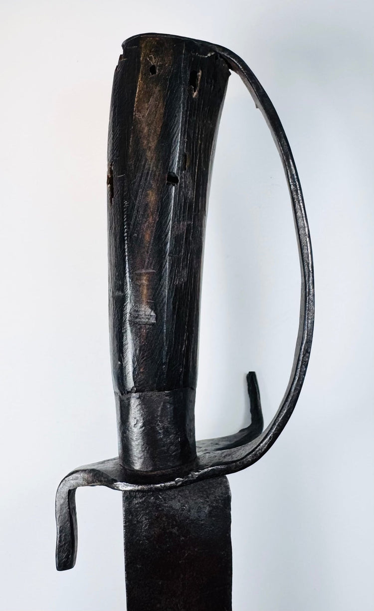 Detail of the iron ferrule and plain pommel cap on a blacksmith-made hanger sword