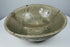 Full view of an early Southeast Asian celadon bowl with rounded sides and an everted rim
