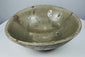 Full view of an early Southeast Asian celadon bowl with rounded sides and an everted rim