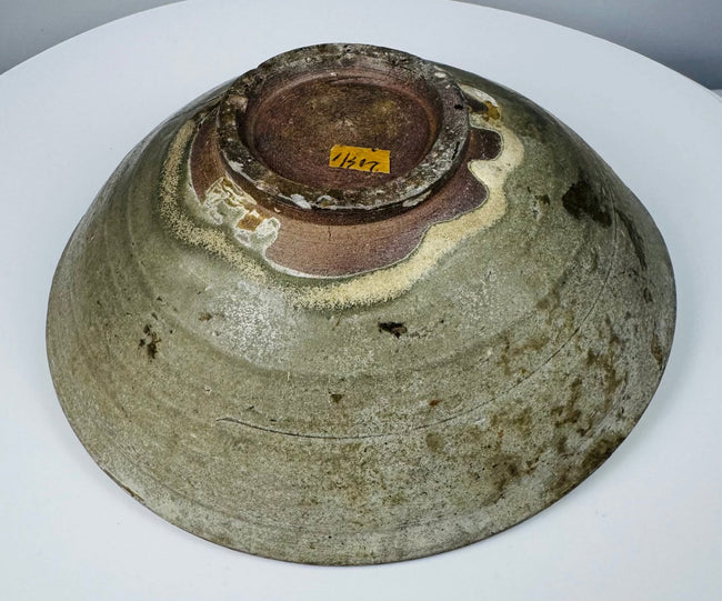 Detail of cracks, rim chips, glaze losses and surface deposits on an ancient celadon vessel