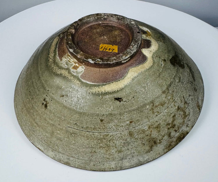 Detail of cracks, rim chips, glaze losses and surface deposits on an ancient celadon vessel