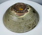 Detail of cracks, rim chips, glaze losses and surface deposits on an ancient celadon vessel