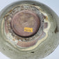 Historic white collection label preserved inside a 12th–14th-century Vietnamese bowl