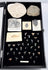 Open natural history presentation case displaying fossil specimens on a black velvet-lined interior