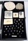Open natural history presentation case displaying fossil specimens on a black velvet-lined interior