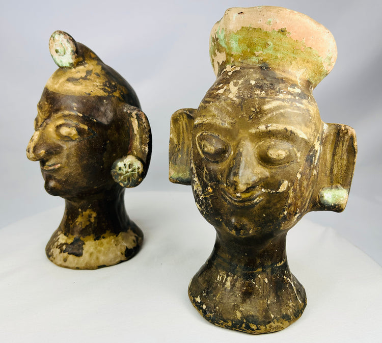 Matched terracotta ceremonial heads with stylized facial features and dark slipped surfaces