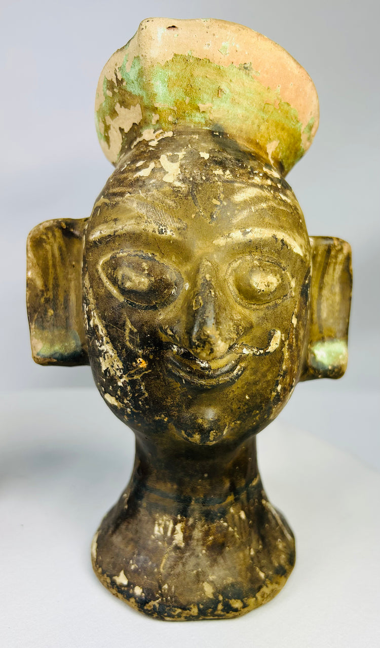 Decorative terracotta ceremonial heads with rounded headdress knops and strong visual symmetry