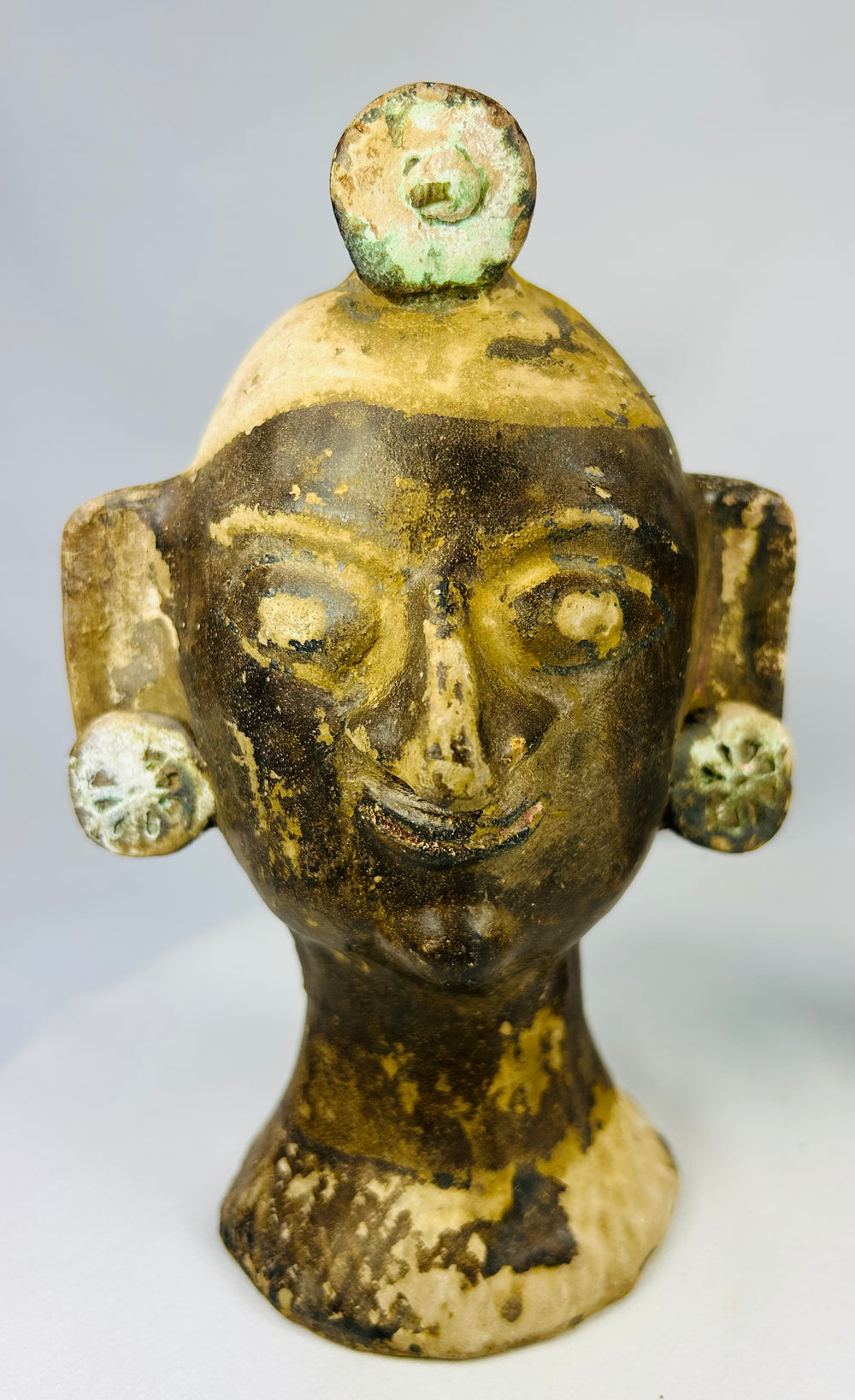 Antique-style Central American terracotta head sculptures showing textured surfaces and wear