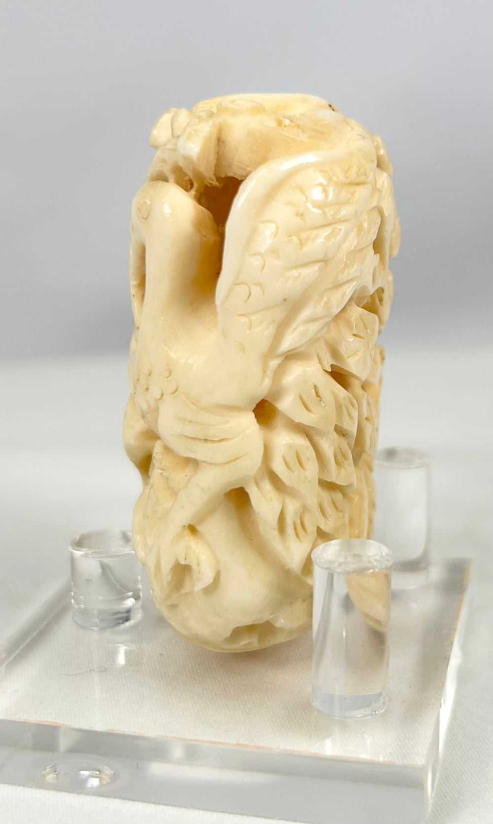 Intricately pierced Japanese bone sculpture showing birds among flowing leaves, circa 1890–1930