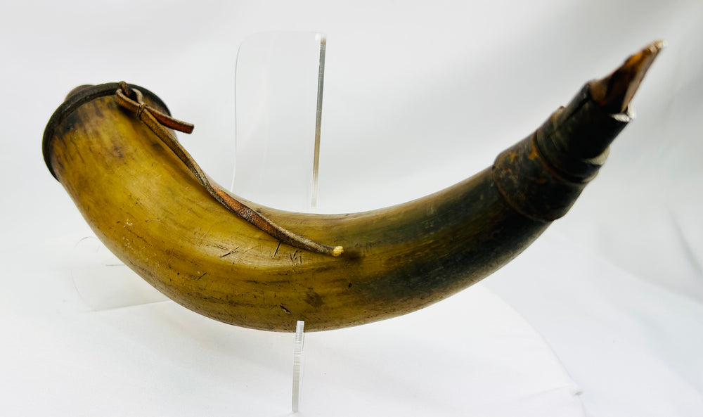 Authentic 1700s–1800s powder horn showing warm horn coloration and period wear