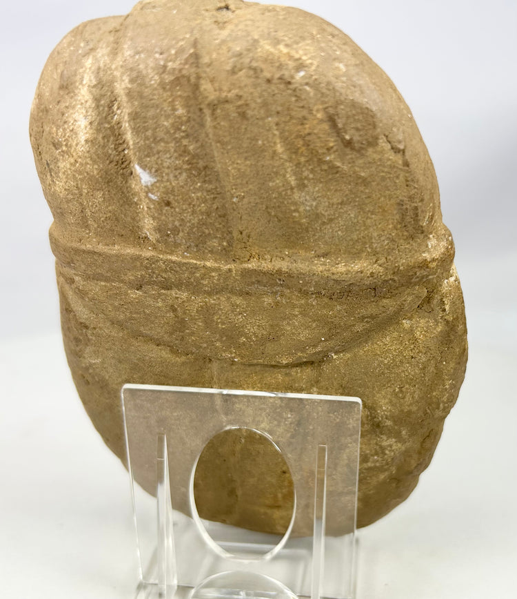 Hand-carved stone effigy plaque depicting helmeted warrior face