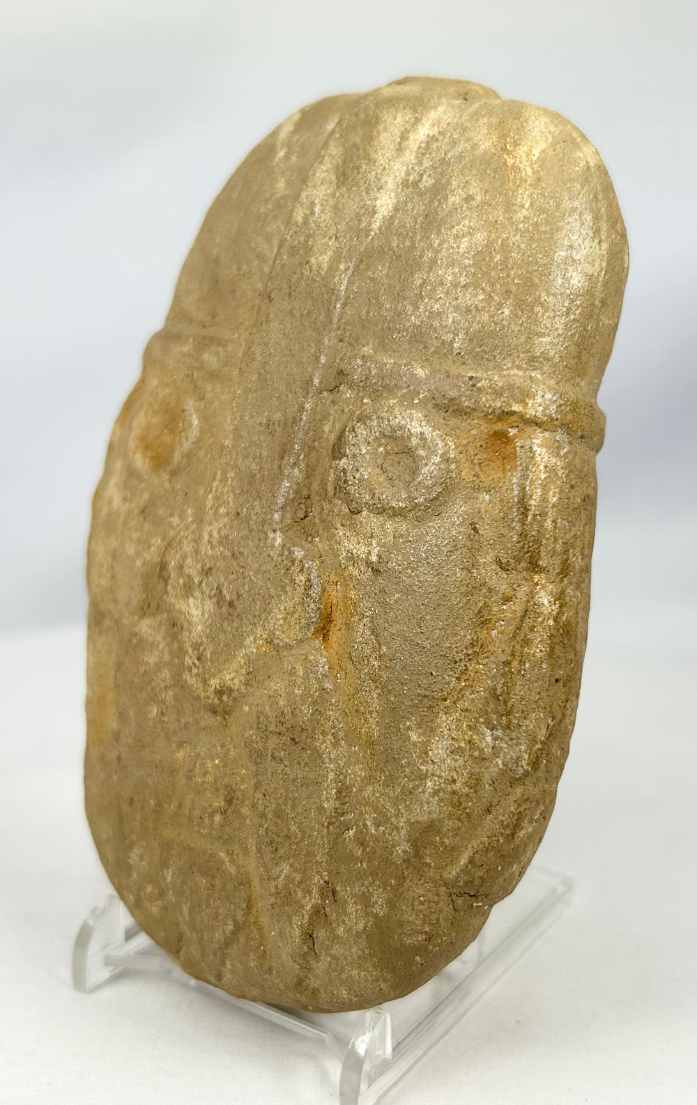 Mysterious stone warrior carving with domed helmet and defined brow
