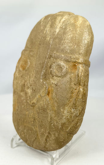 Mysterious stone warrior carving with domed helmet and defined brow