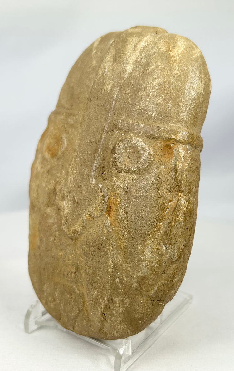 Mysterious stone warrior carving with domed helmet and defined brow