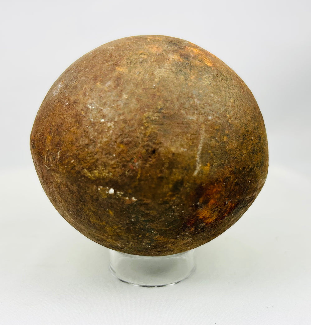Historic iron artillery cannonball displaying aged rust and battlefield wear