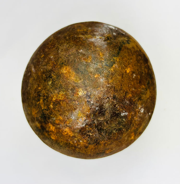 Early artillery iron shot featuring corroded surface, rust tones, and historic character