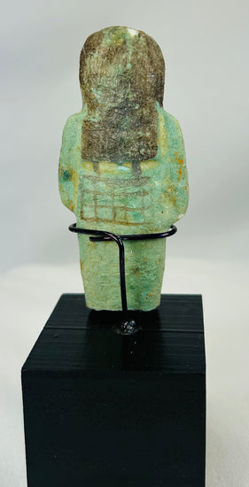 Blue-green faience ushabti with painted face, arms, and symbolic agricultural tools