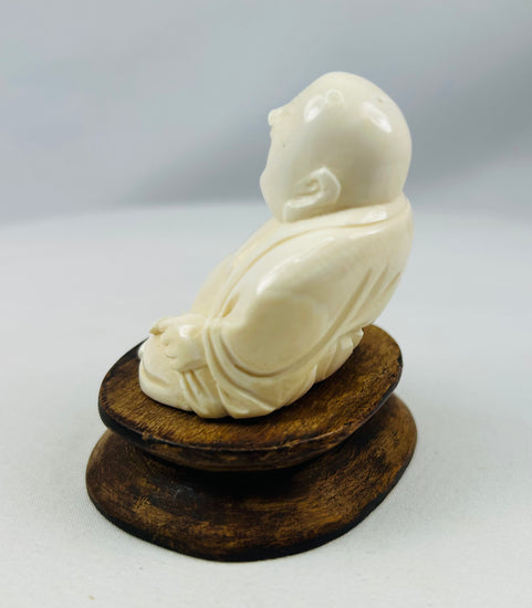 Carved Budai statue representing good fortune displayed on fitted wood base
