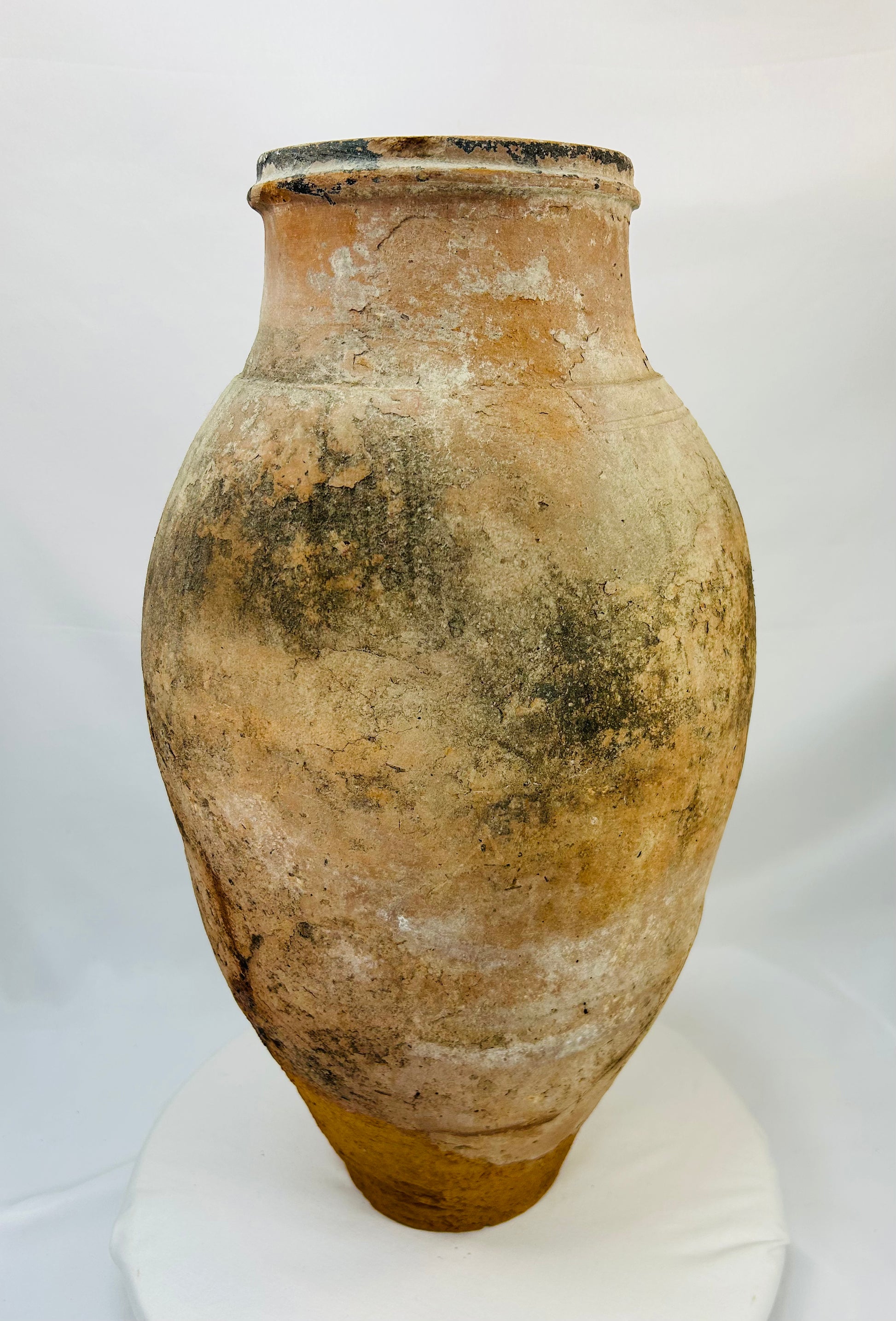 Archaeological terracotta amphora showing ancient repair line and historical surface weathering