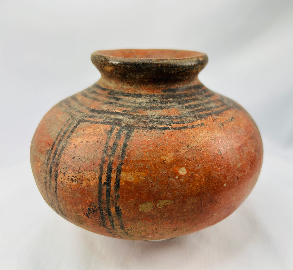 Traditional West African hand-coiled terracotta vessel with painted designs