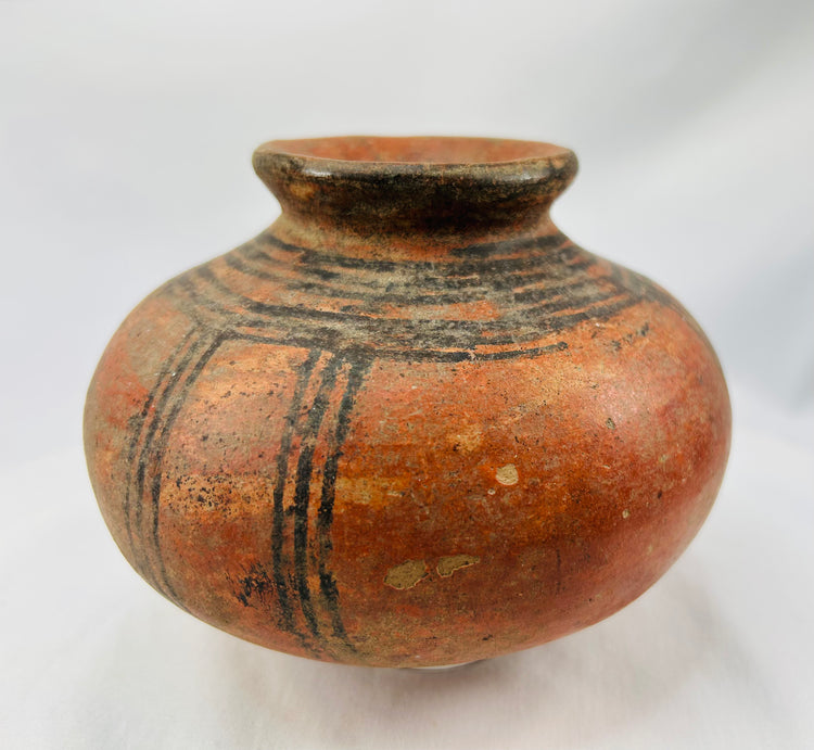 Traditional West African hand-coiled terracotta vessel with painted designs