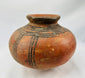 Traditional West African hand-coiled terracotta vessel with painted designs