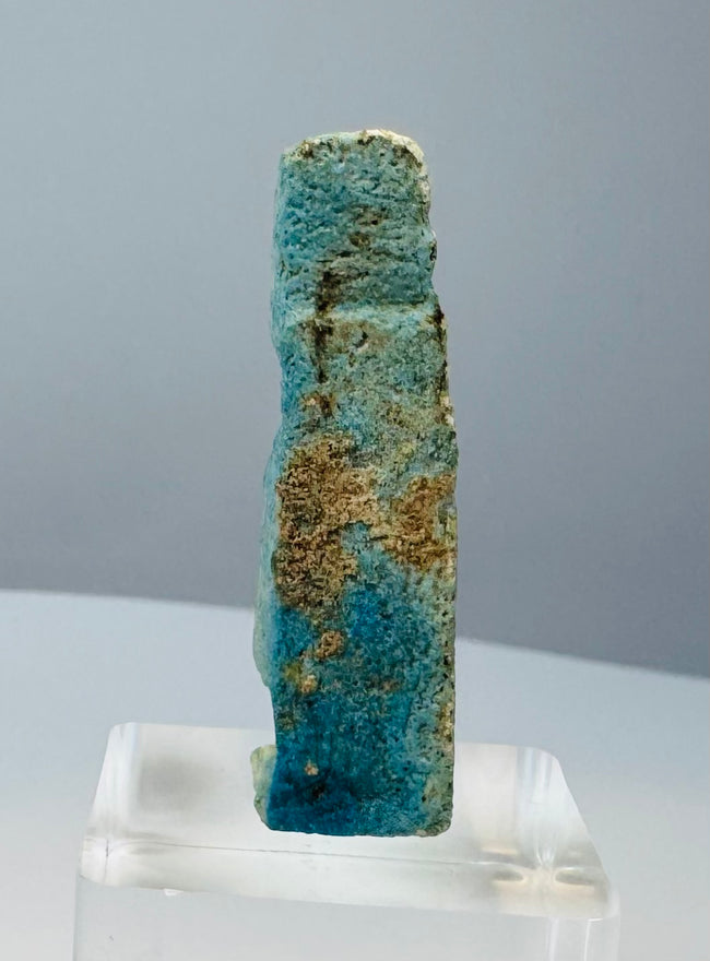 Small mold-formed Egyptian faience amulet with turquoise-blue and green glaze remnants
