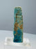 Small mold-formed Egyptian faience amulet with turquoise-blue and green glaze remnants