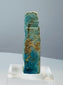Small mold-formed Egyptian faience amulet with turquoise-blue and green glaze remnants