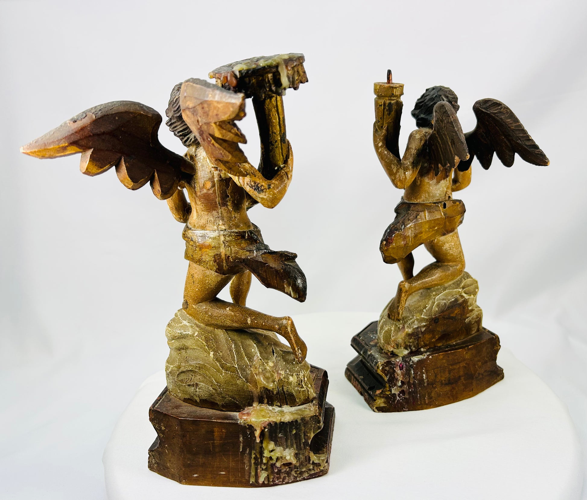 Matched pair of antique putti figures with candle or torch holders and aged patina