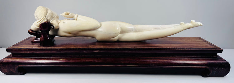 Opposite side view showing the sculpture’s extended legs, pointed footwear and warm surface patination