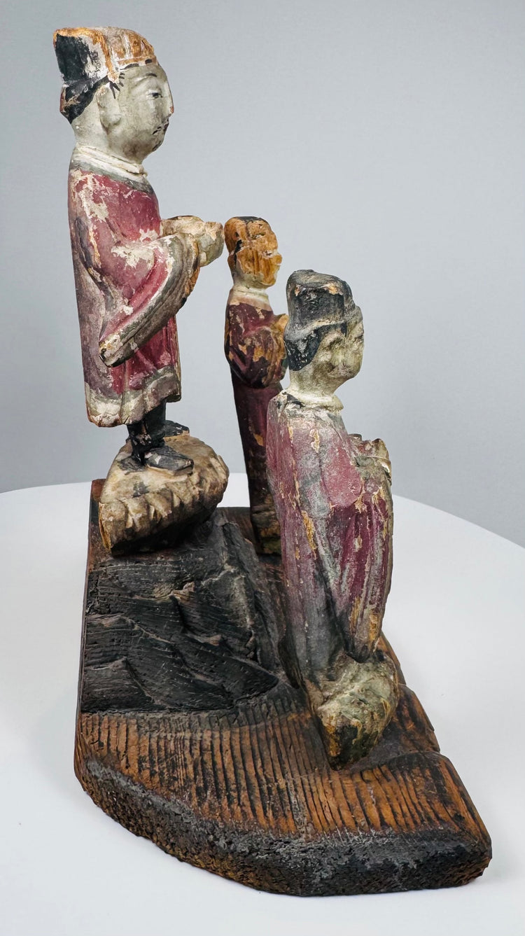 Historic patination, exposed wood, pigment loss and incised decoration across the architectural base