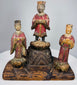 Two flanking attendants in red robes standing upon individual carved lotus-form pedestals