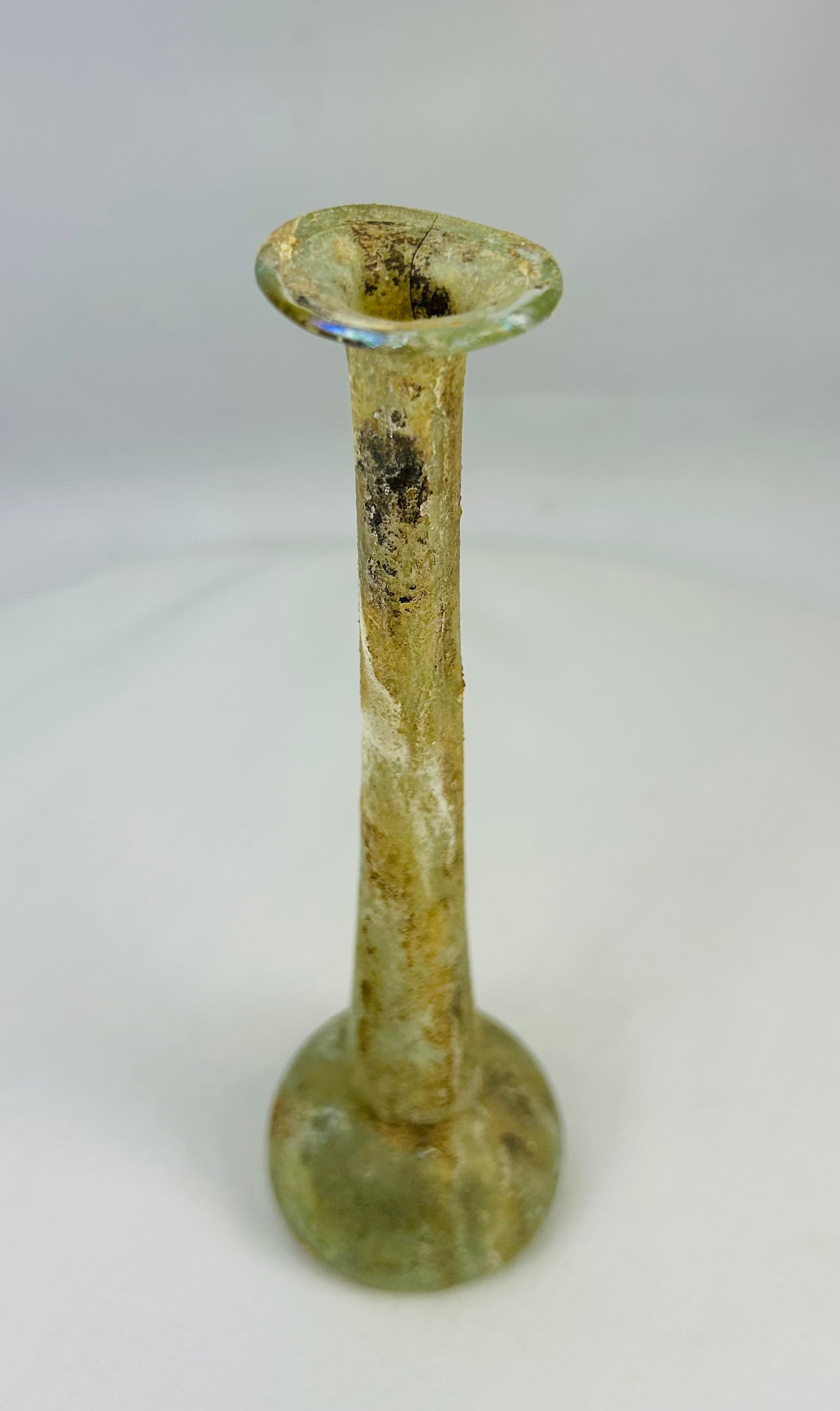 Antique Roman glass ointment bottle showcasing historical mineral surface patination